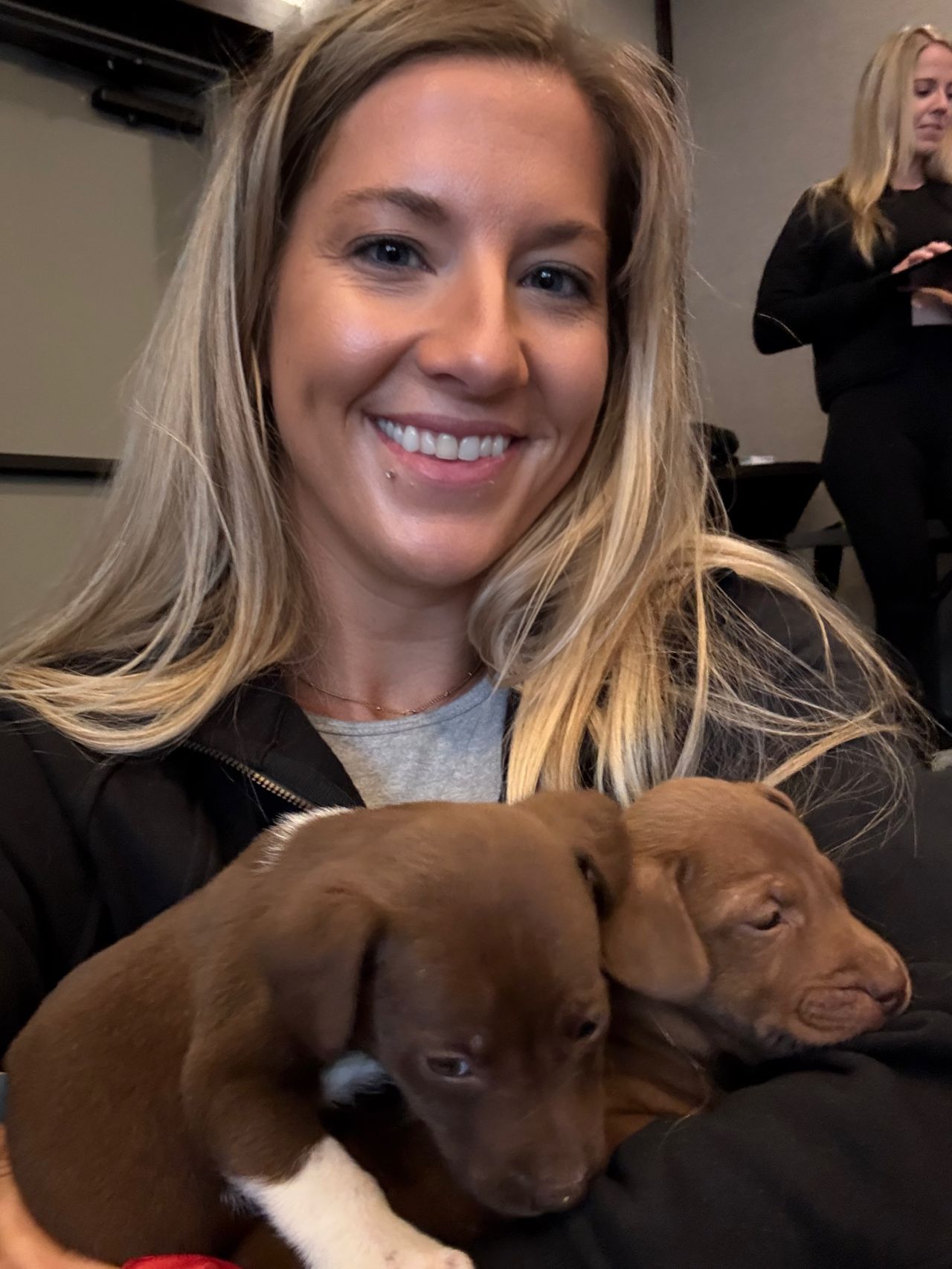 Momentum 2025 attendee smiles with a puppy